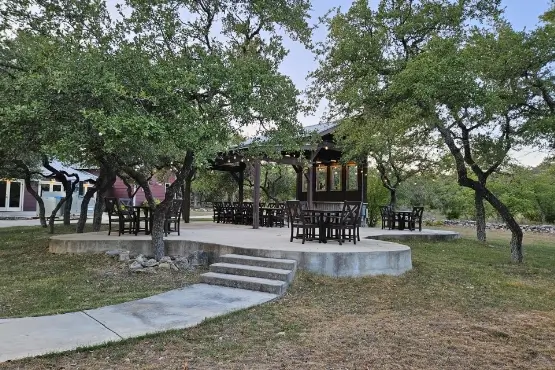 A concrete patio with chairs and a gazebo
