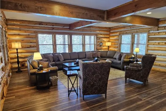 Large U-shaped couch and chairs in a log sided living room