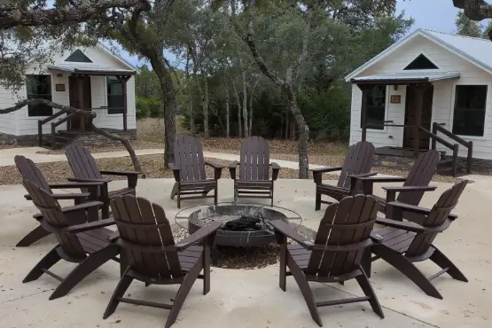 Outside fire pit surrounded by adirondack chairs