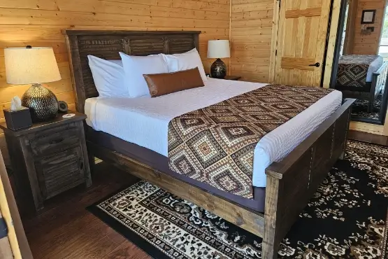 Queen sized bed with two bedside stands in a private room