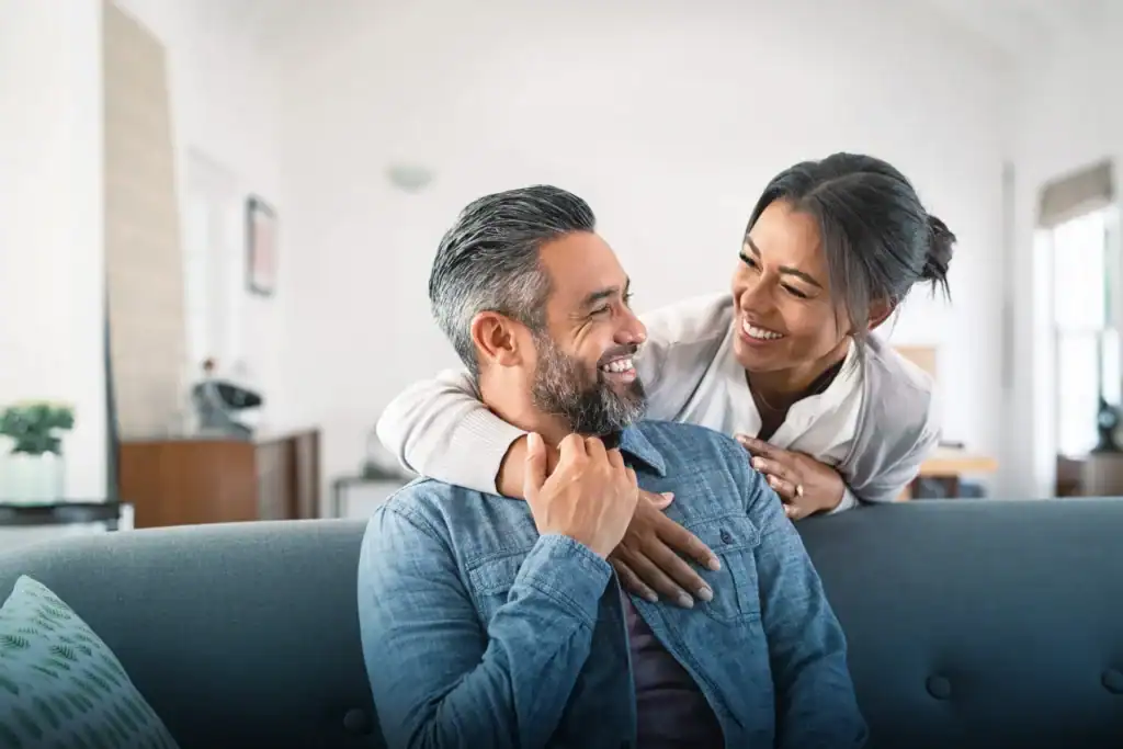 Happy interracial couple by decorative water feature in park setting